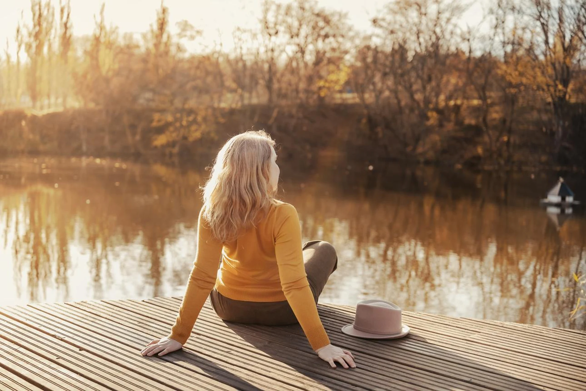 Person sitting peacefully beside a calm lake, representing body neutrality, self-acceptance and a kinder approach to change