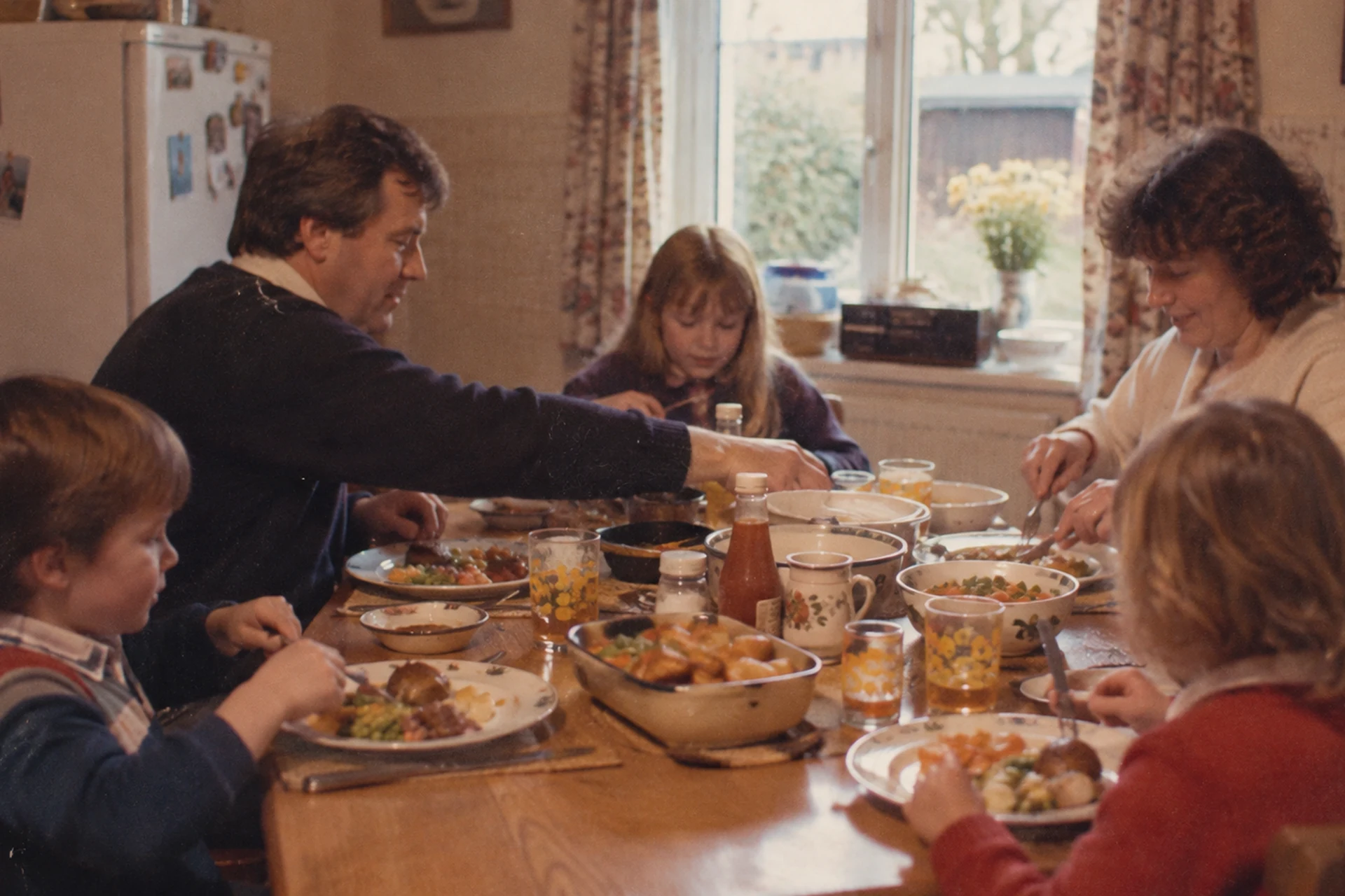 Family sharing a meal around a table, representing how childhood experiences can shape our relationship with food